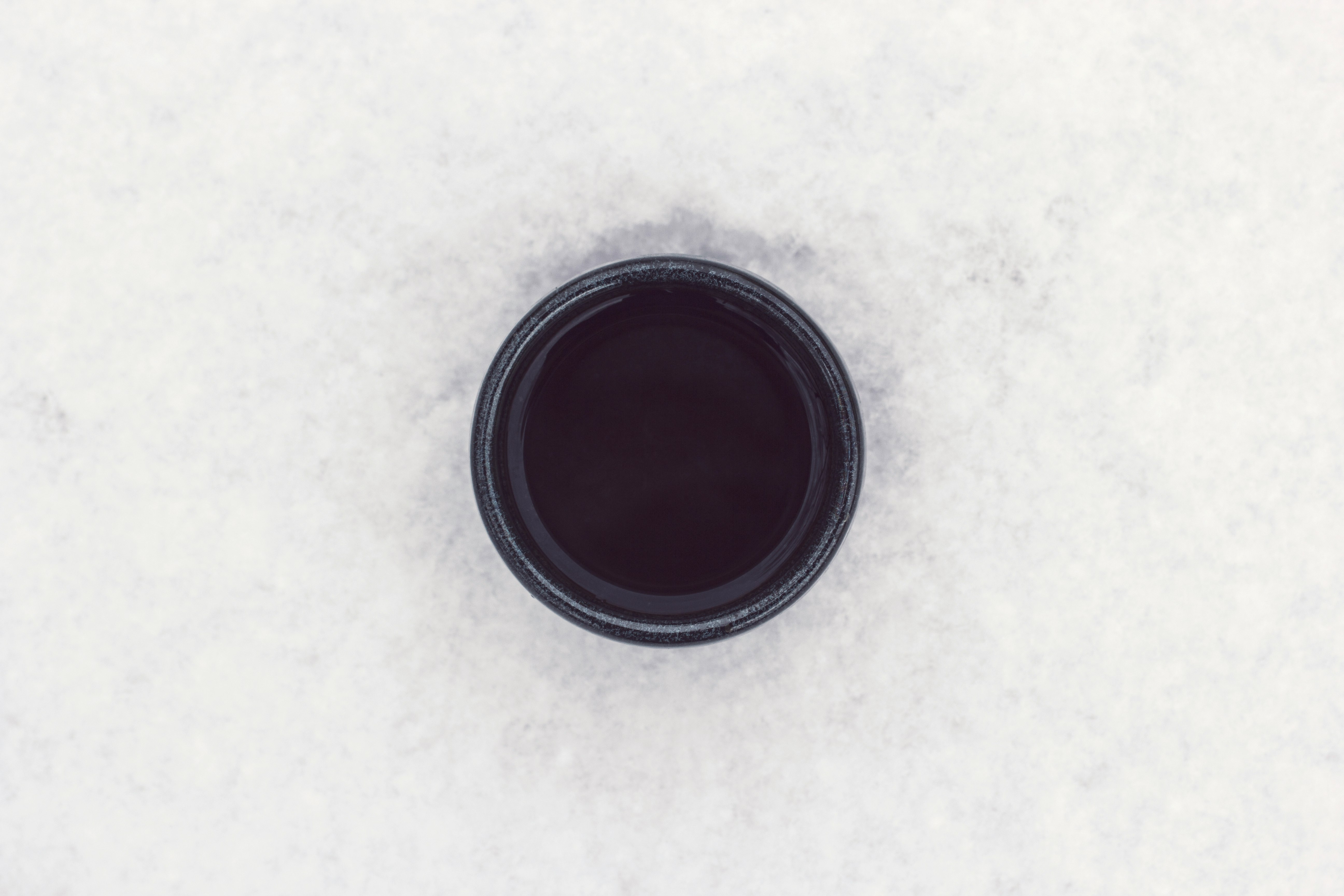 round black container on top of white surface